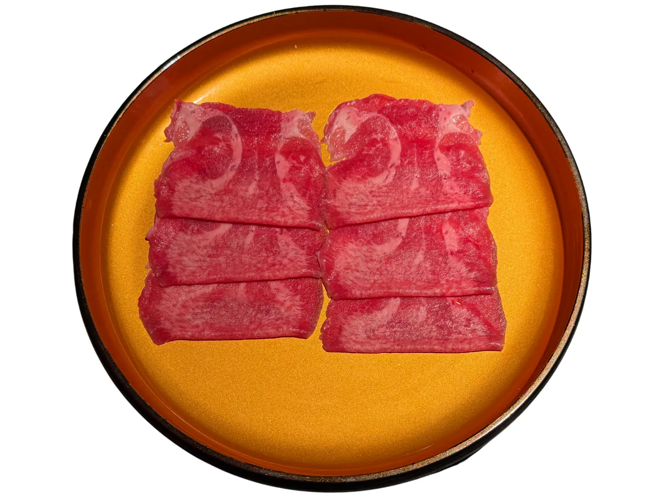Thinly sliced premium beef presented on a golden plate at KTOP Korean BBQ and Hot Pot, an Asian Restaurant in Longview
